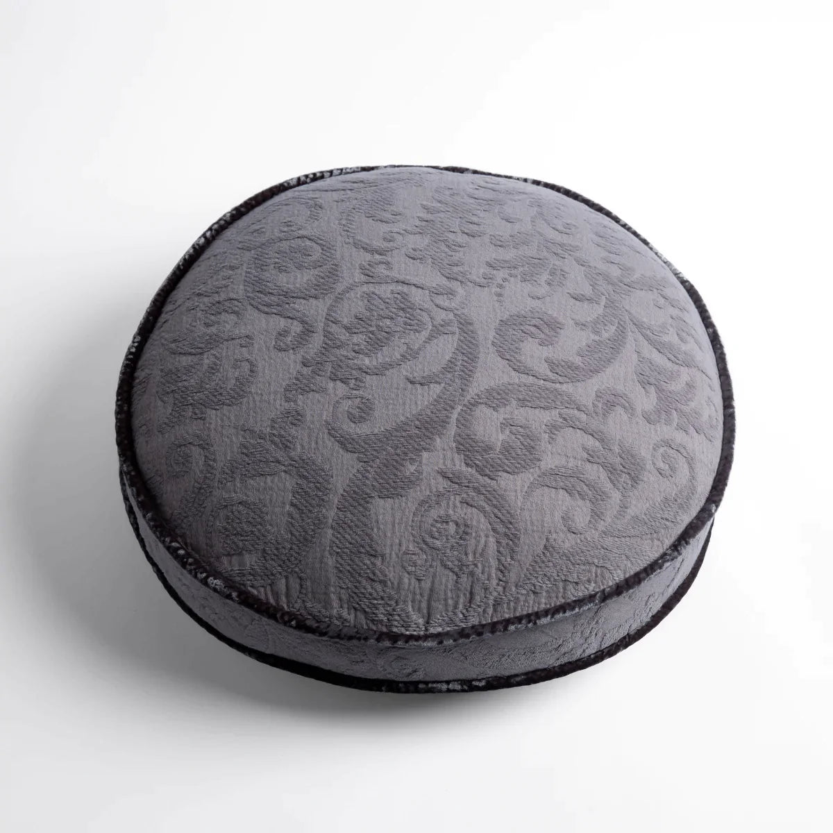 Moonlight: Organic cotton damask round pillow with silk velvet trim on white background — overhead angle.