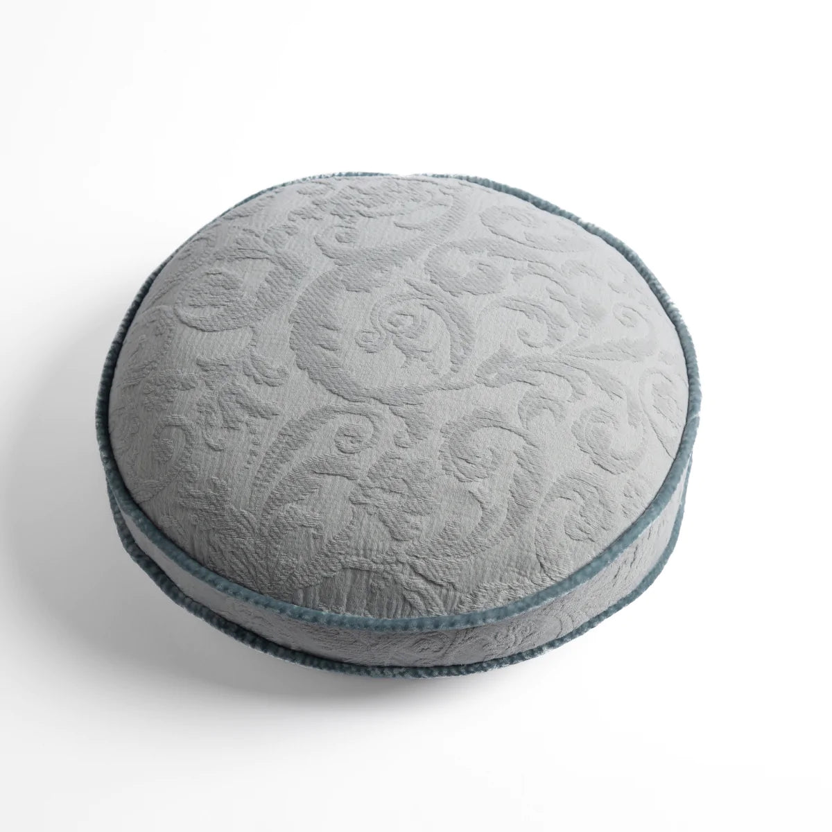 Cloud: Organic cotton damask round pillow with silk velvet trim on white background — overhead angle.