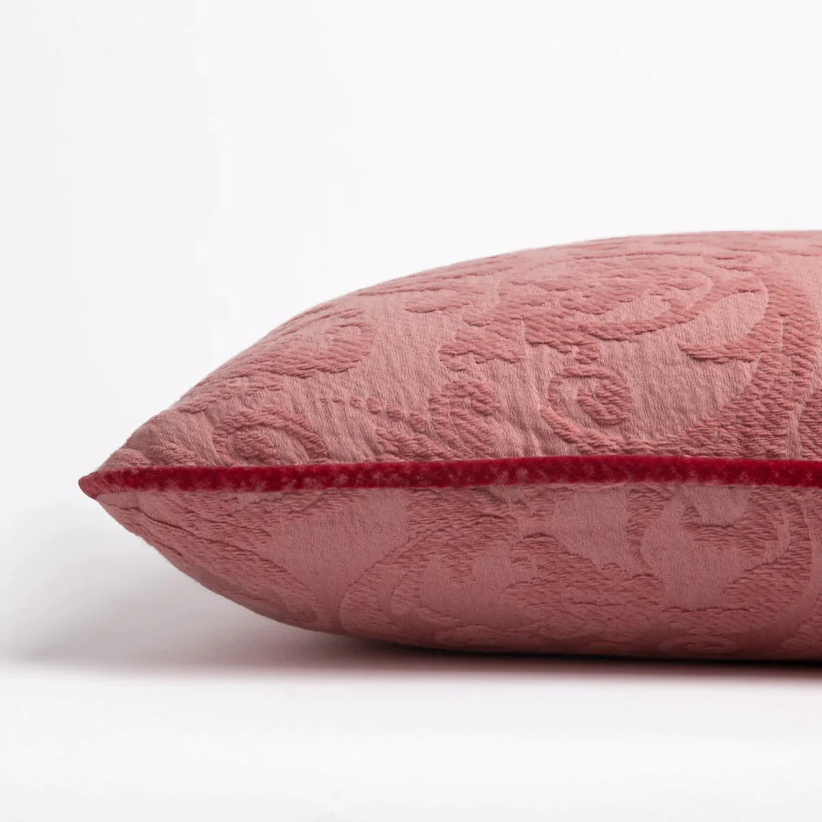 Poppy: Organic cotton damask square pillow with silk velvet trim on white background — side angle.