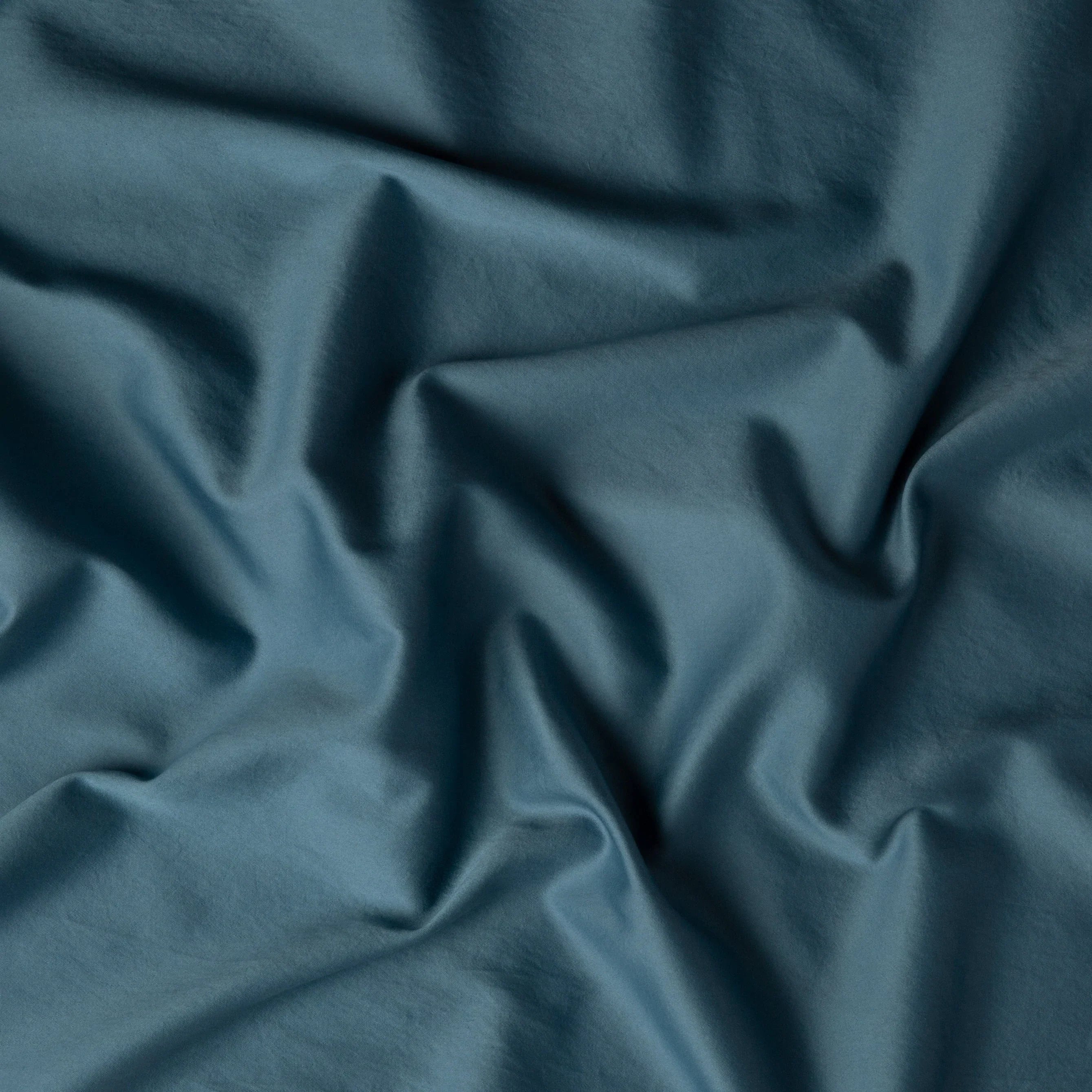 Cenote: A close up of cotton sateen fabric in cenote, a vibrant, ocean-inspired blue-green.