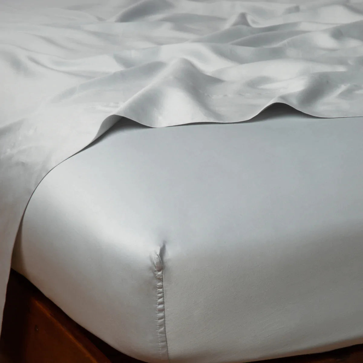 Cloud: Cotton sateen fitted sheet shown from the top corner, highlighting the shine of the fabric.