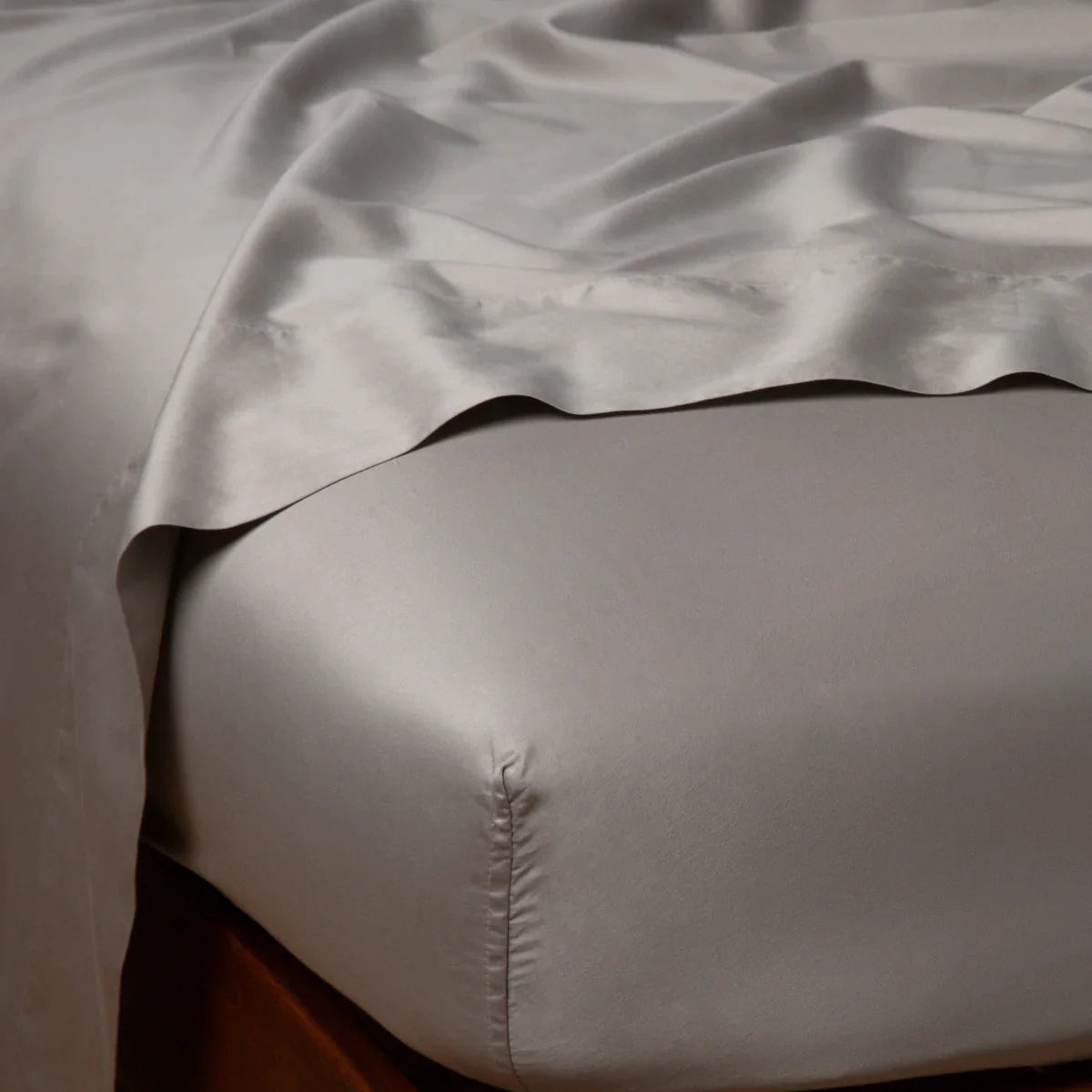 Fog: Cotton sateen fitted sheet shown from the top corner, highlighting the shine of the fabric.