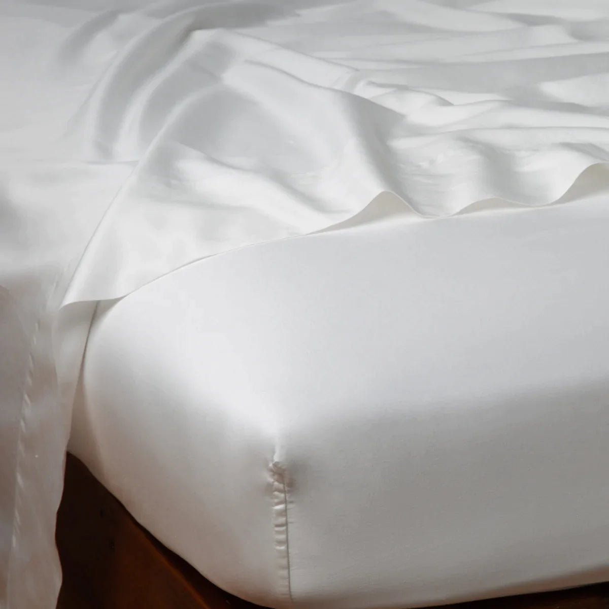 Winter White: Cotton sateen fitted sheet shown from the top corner, highlighting the shine of the fabric.