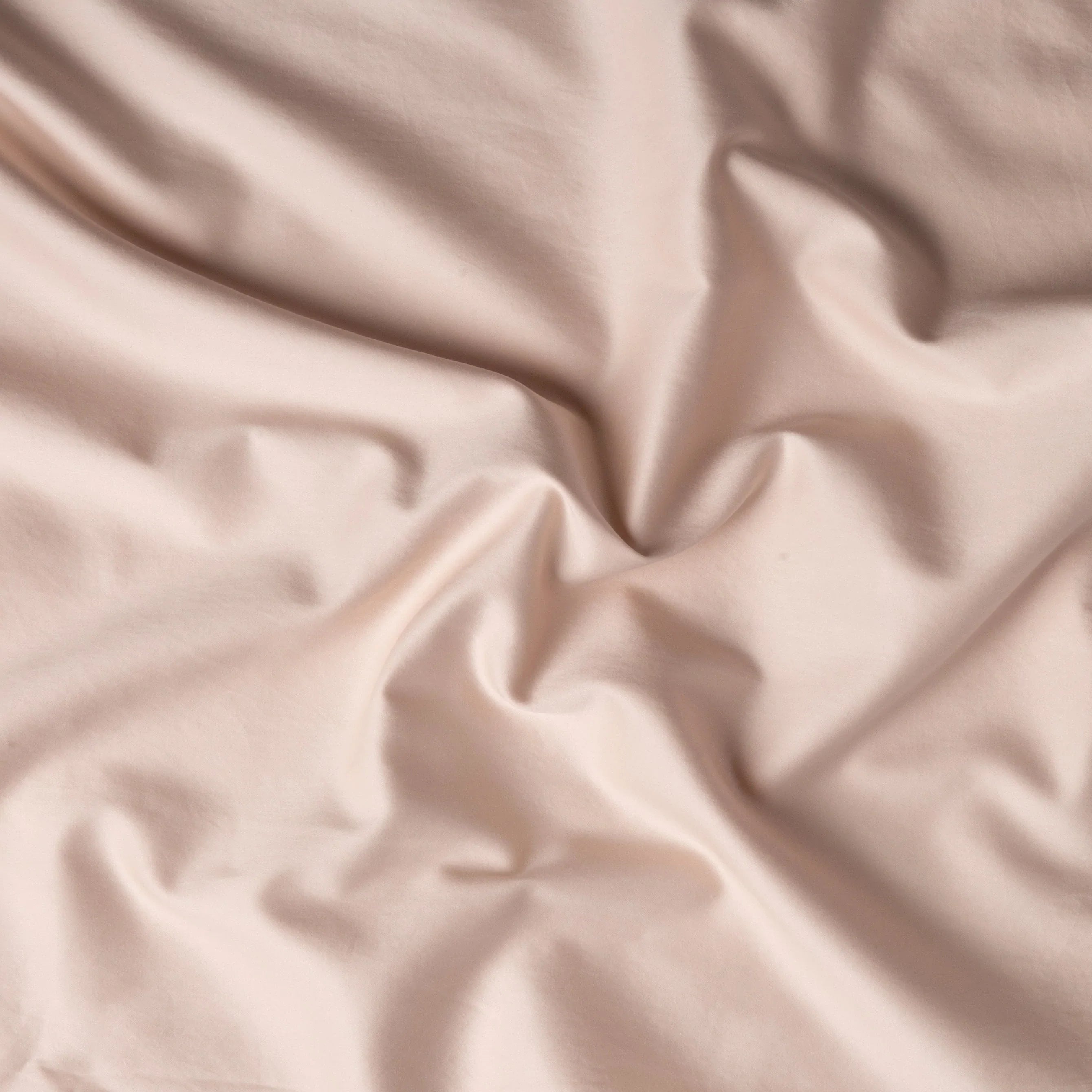 Pearl: A close up of cotton sateen fabric in pearl, a nude-like, soft rose pink tone.