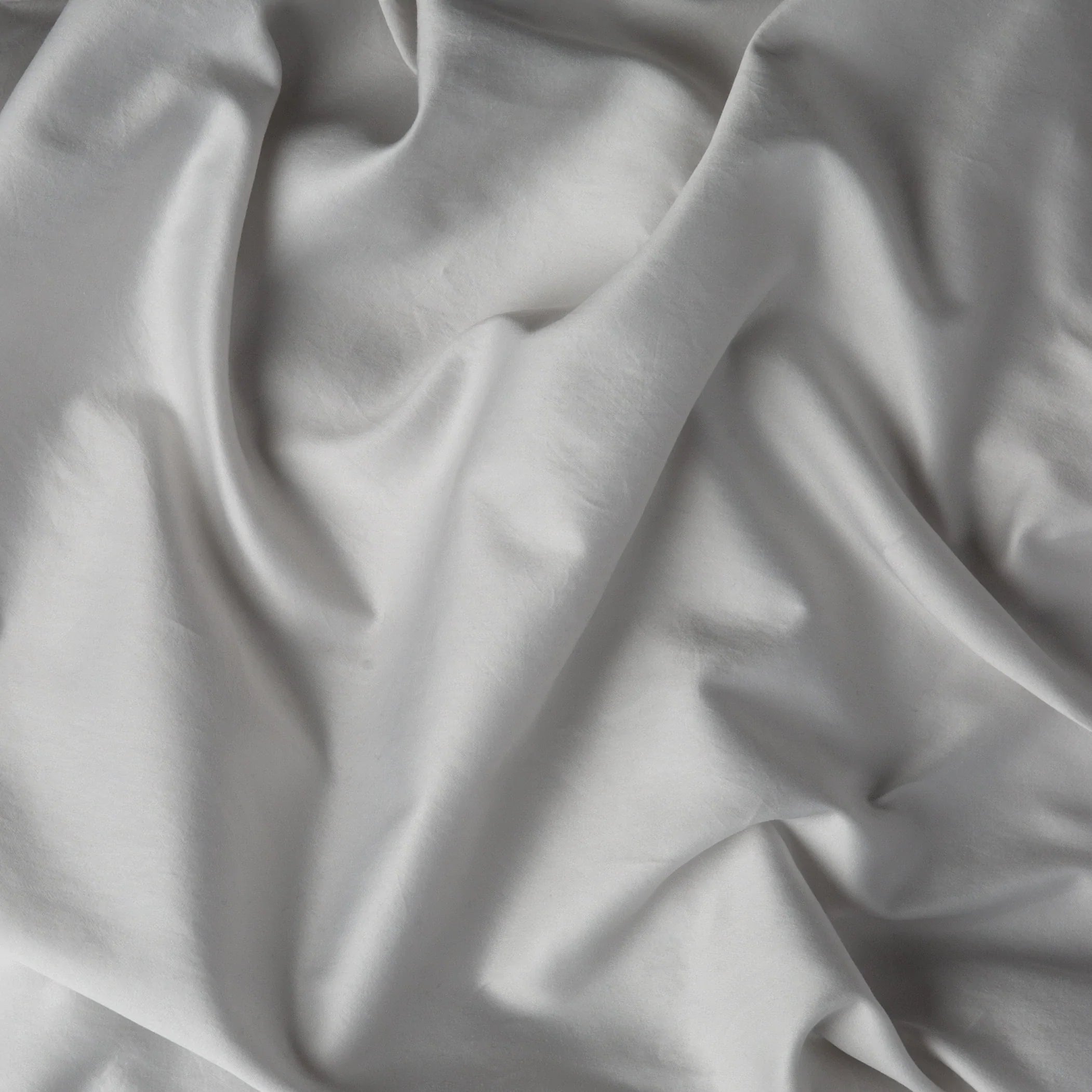 Sterling: A close up of cotton sateen fabric in sterling, a silvery neutral light grey.