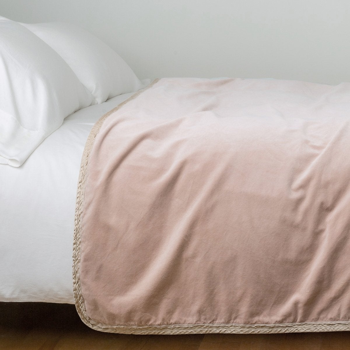 Pearl: Cotton velvet bed end sized blanket, draped on a white bed - side view.
