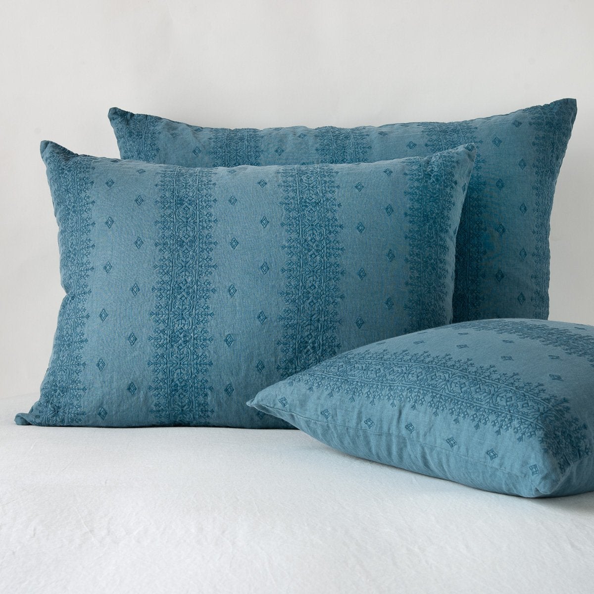 Cenote: two shams leaning upright and one laying flat at an angle, against a white background.