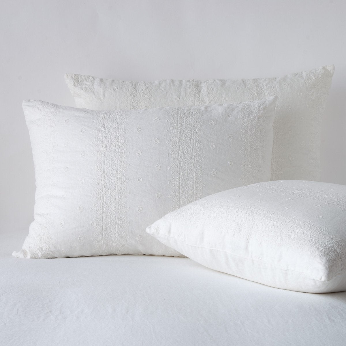 Winter White: two shams leaning upright and one laying flat at an angle, against a white background.