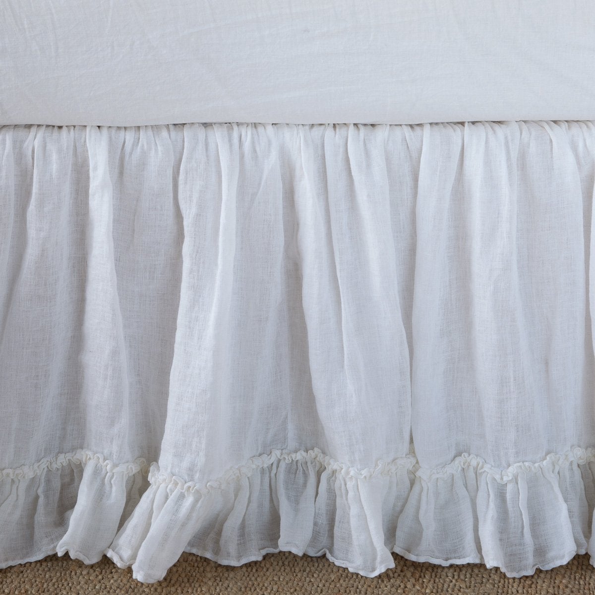 : Close-up of Linen Whisper bed skirt, showcasing ruffle detail - white.