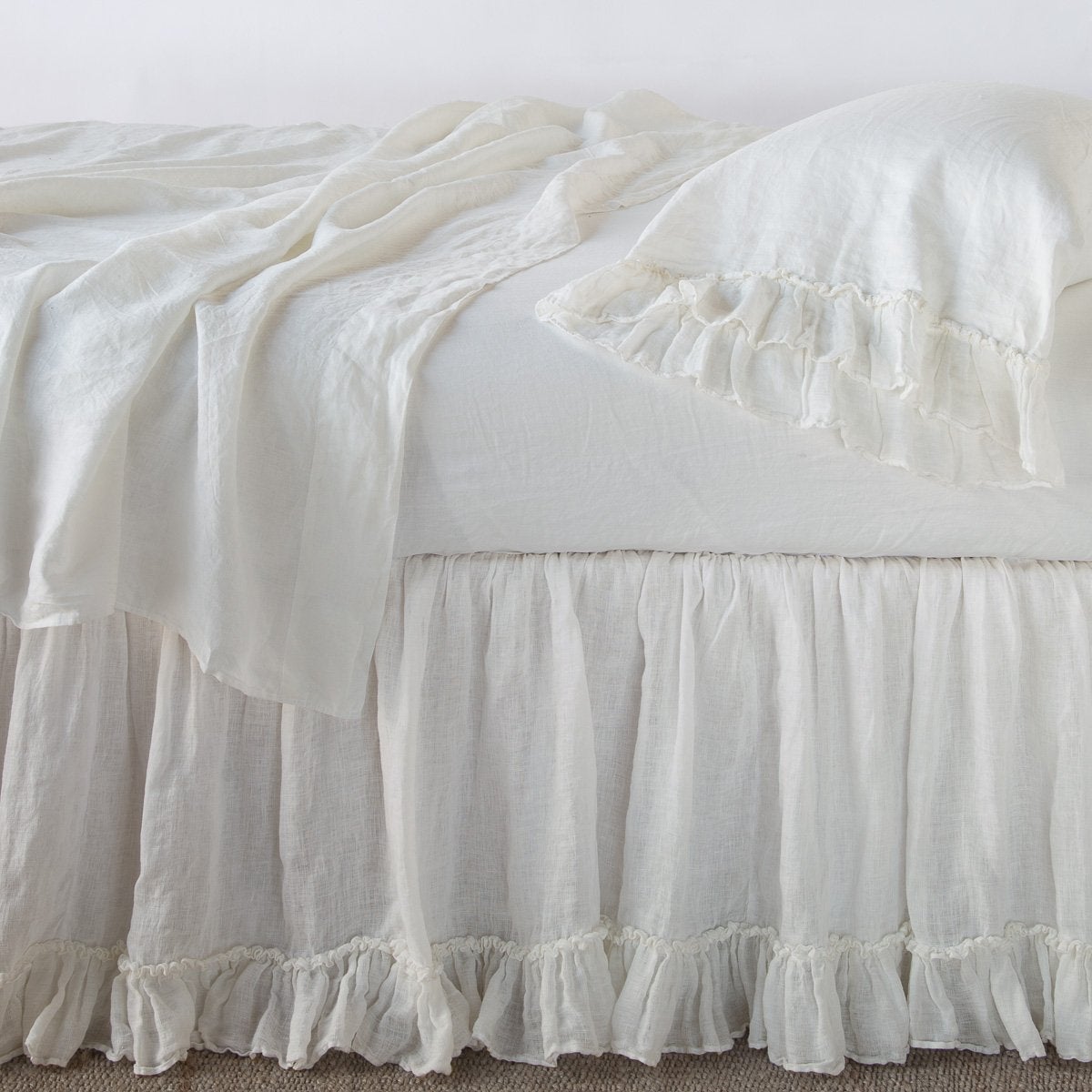 Winter White: bed skirt layered with monochromatic linen sheeting - side view.
