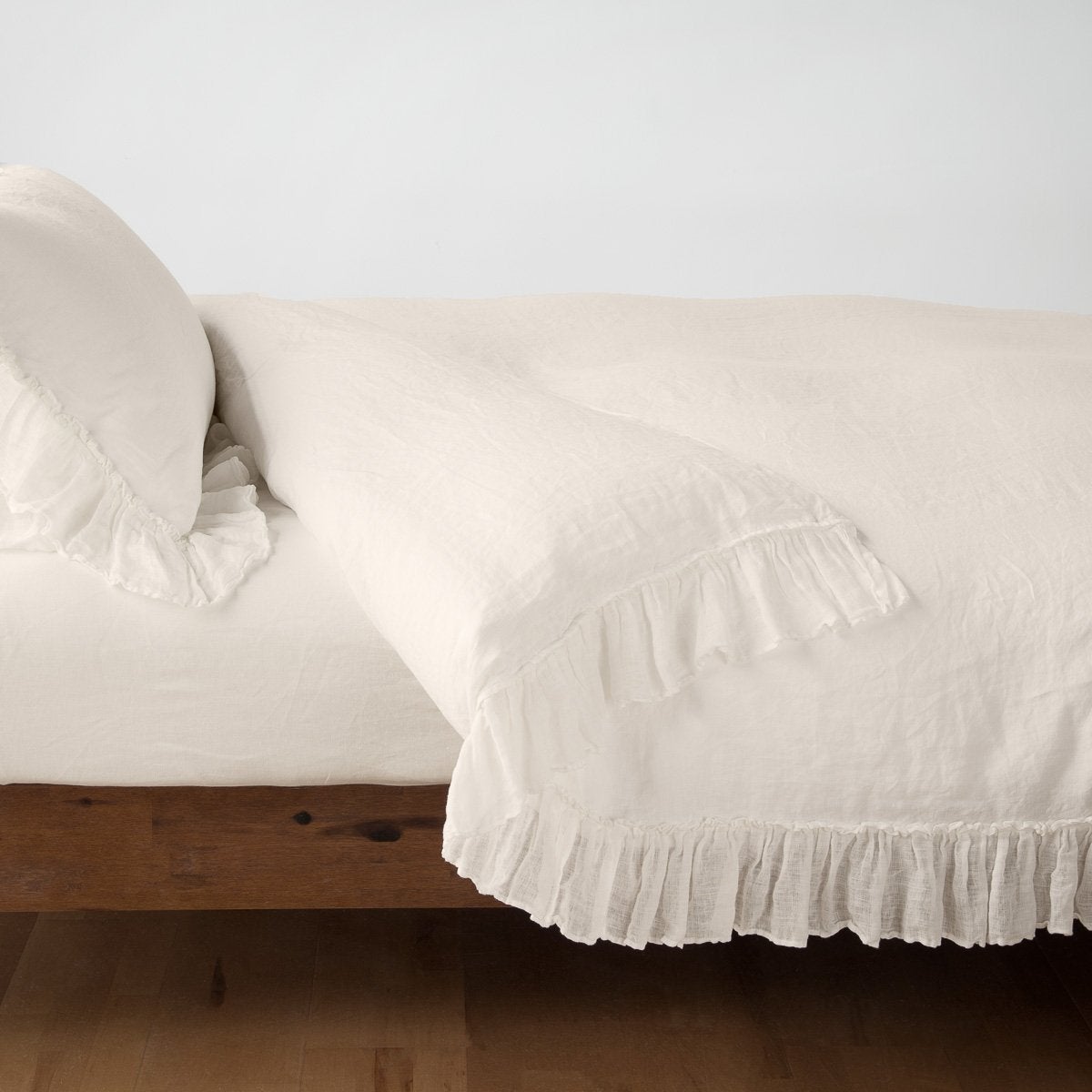 Parchment: duvet cover folded back over a white fitted sheet, shown with matching sham against a plain background - side view.