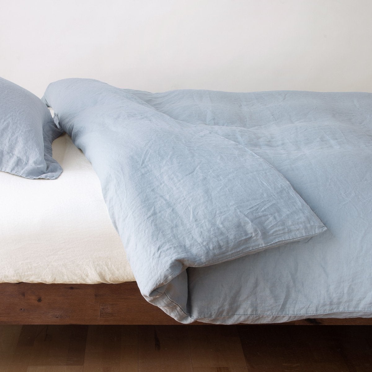 Mineral: duvet cover neatly folded back over white linen sheeting - side view.