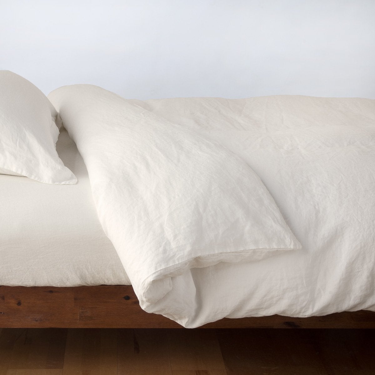 Parchment: duvet cover neatly folded back over matching linen sheeting - side view.