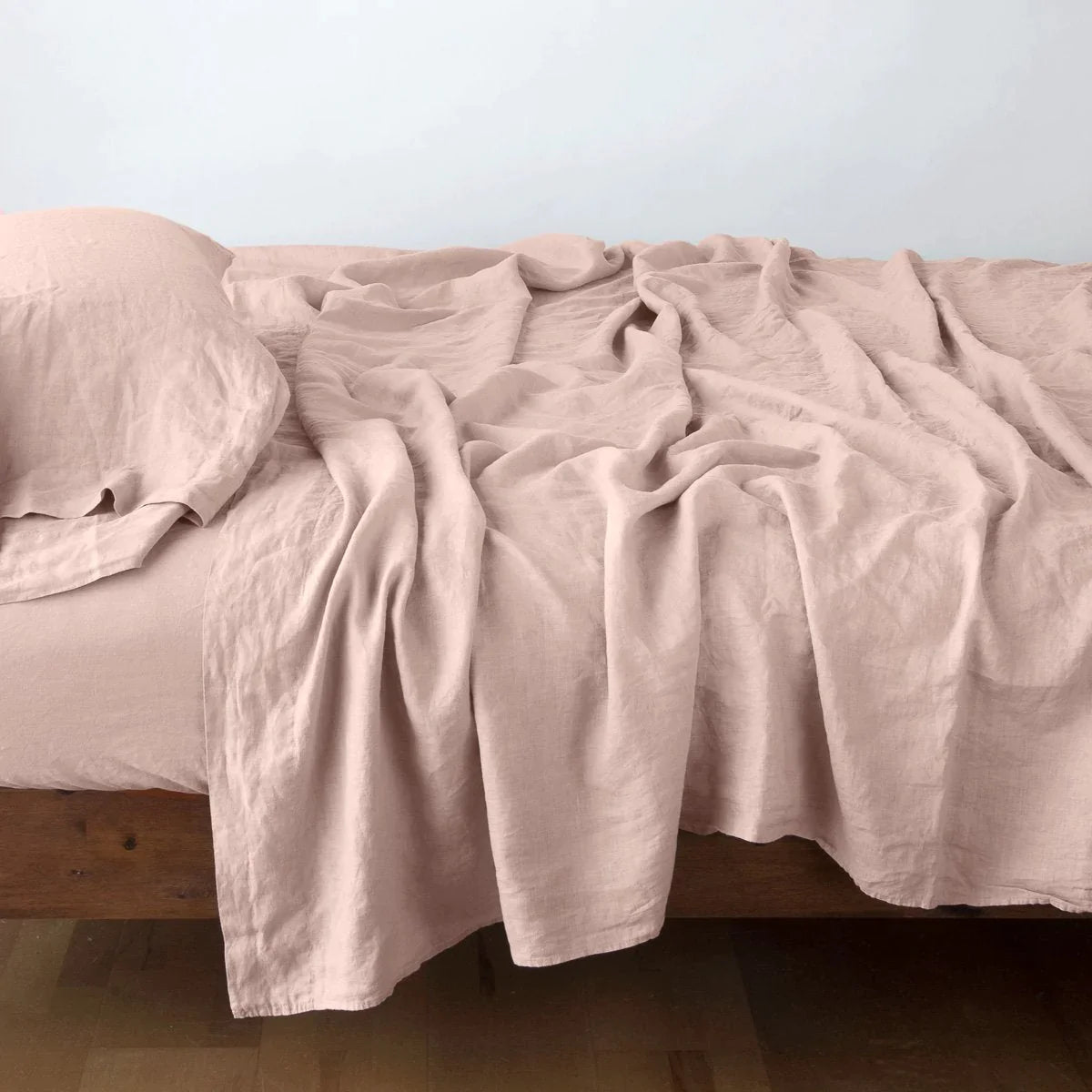 Rouge: Rumpled linen sheeting with matching sleeping pillow - side view.