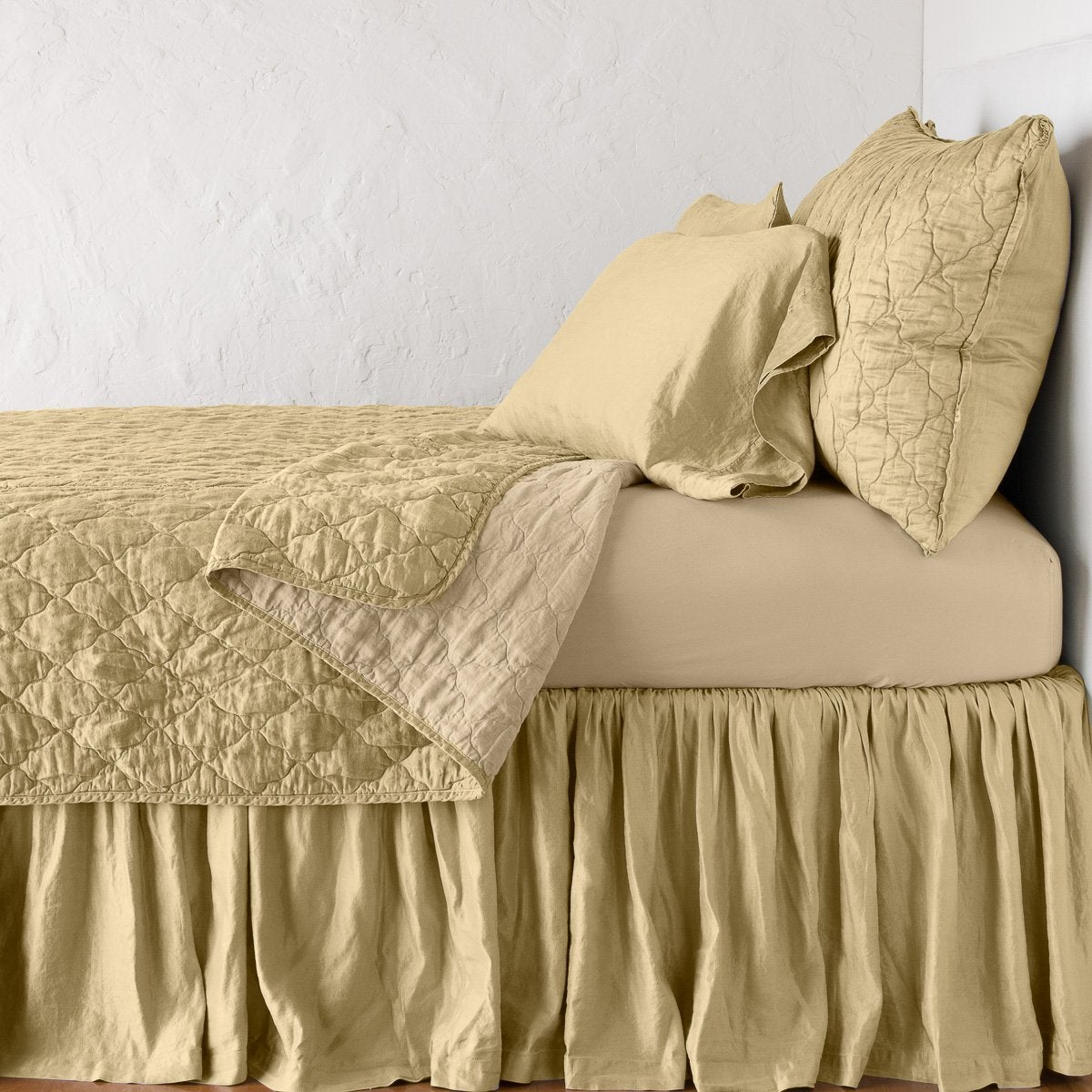 Honeycomb: coverlet neatly folded back to reveal linen reverse, on a monochromatic bed - side view.