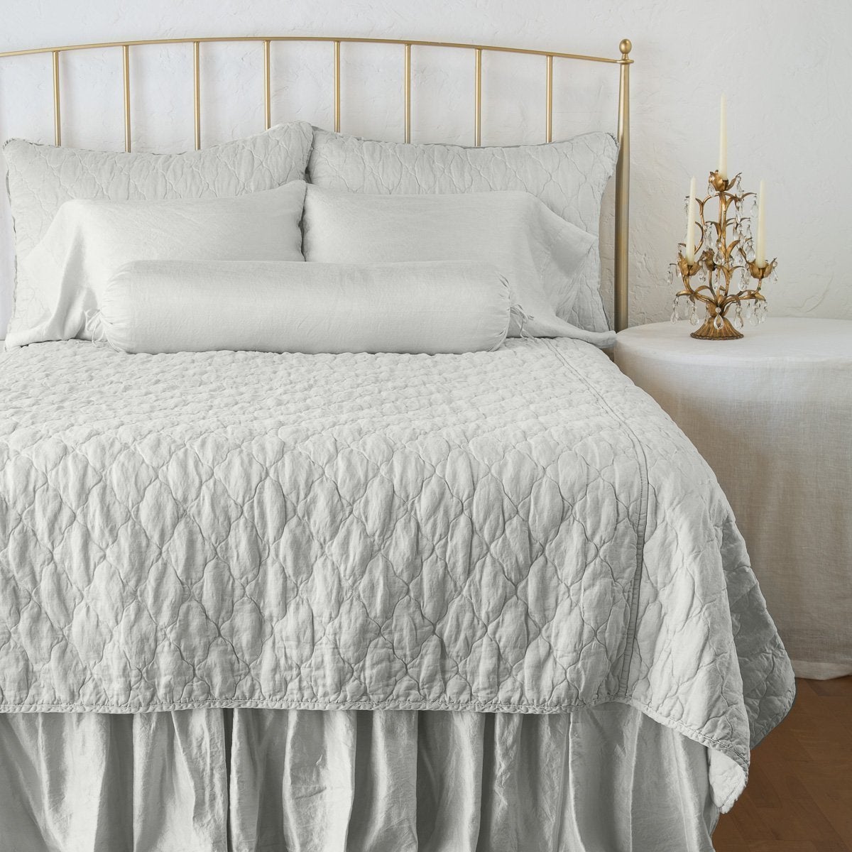 Sterling: coverlet on a shining, monochromatic bed with matching shams - end of bed view.