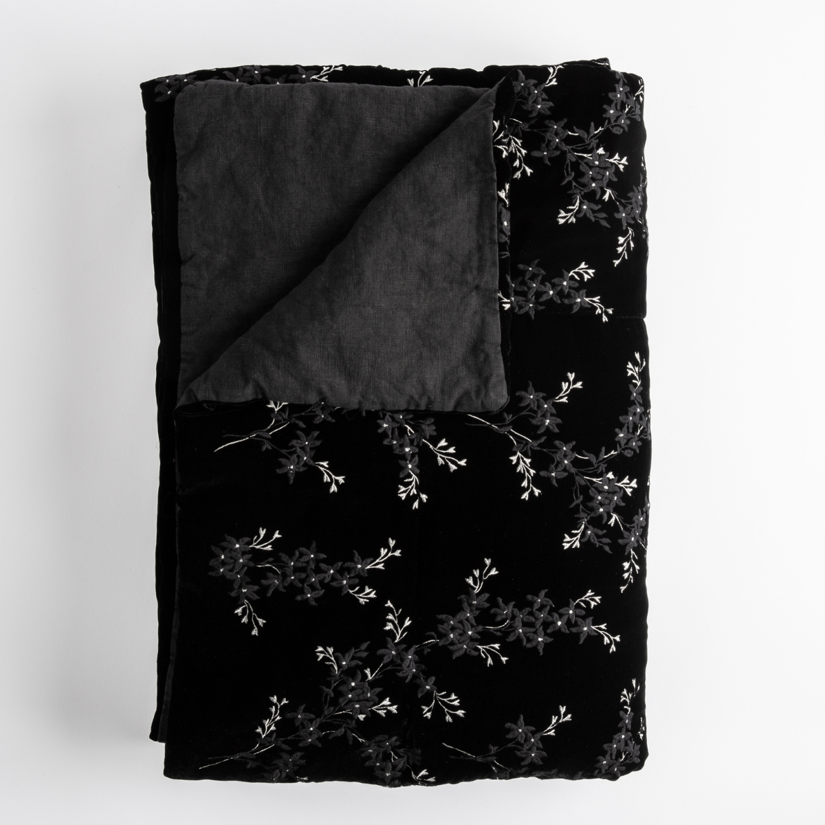 Corvino: Close up of folded blanket, with a corner turned back to showcase the linen back - overhead view.