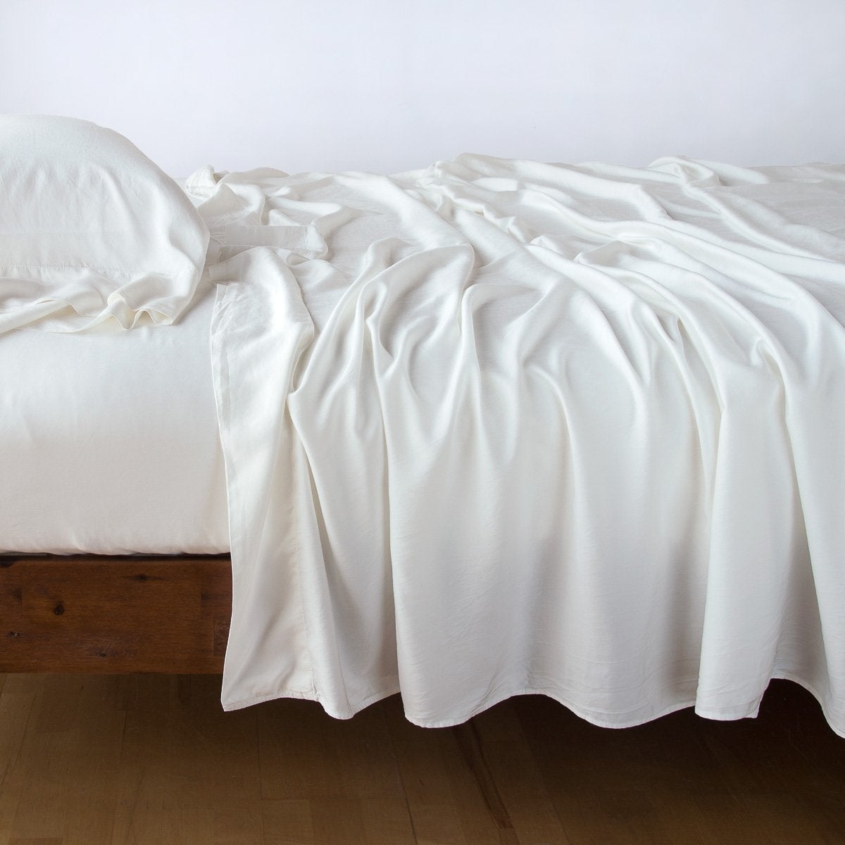 Winter White: sleeping pillow with matching rumpled sheeting - side view.
