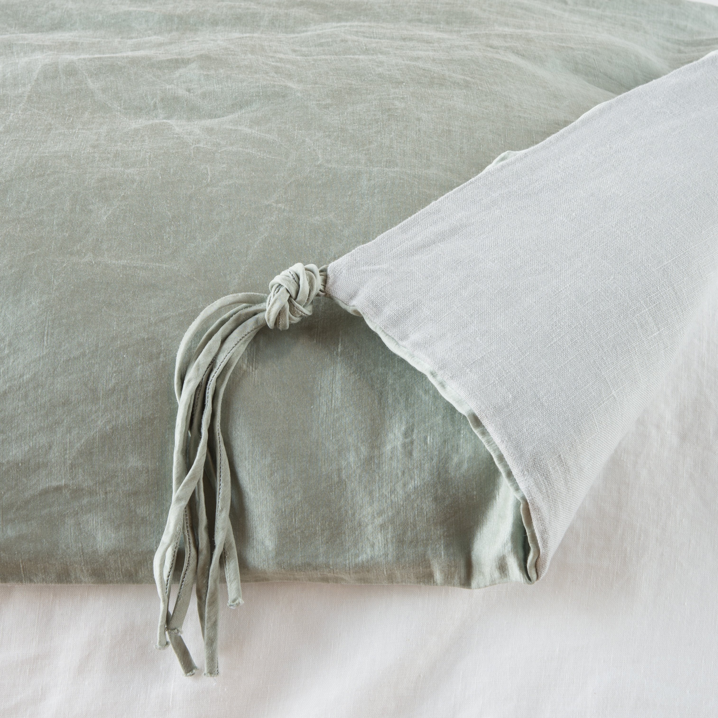 Mineral: Close up of blanket, with a corner turned back to showcase the midweight linen back and corner tassel - overhead view.