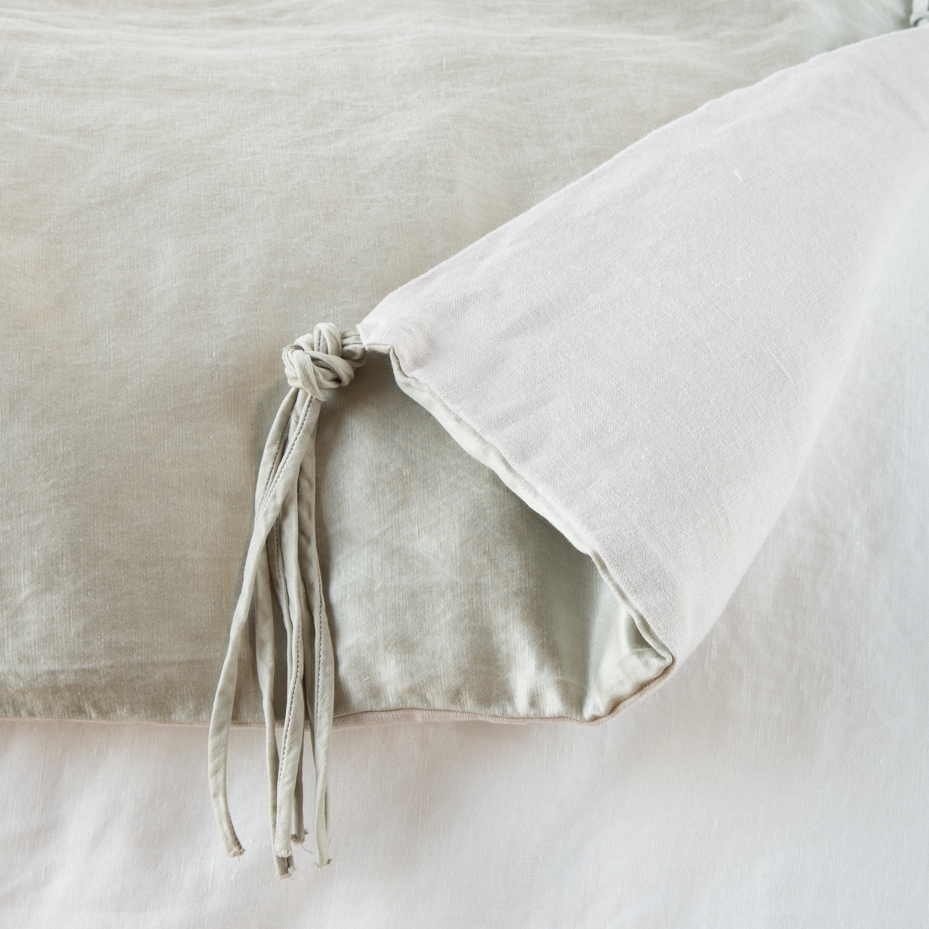 Sterling: Close up of blanket, with a corner turned back to showcase the midweight linen back and corner tassel - overhead view.