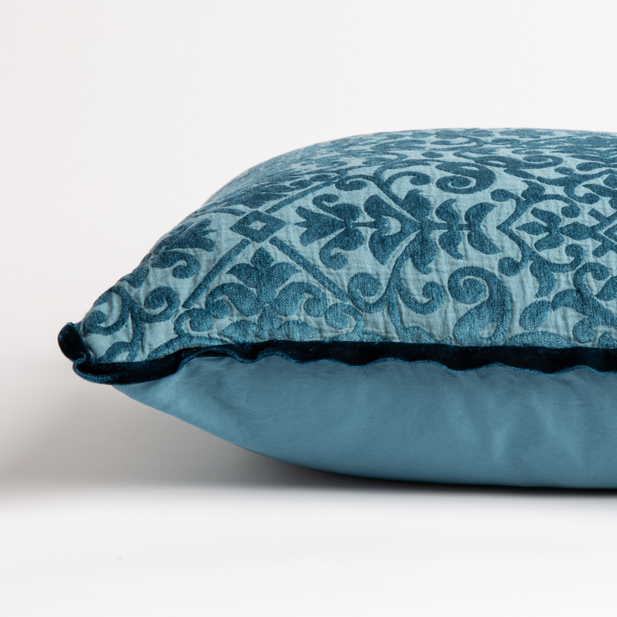 Cenote: side view of 18x18 pillow shows cotton sateen back and silk velvet trim detail — close up against a white background.