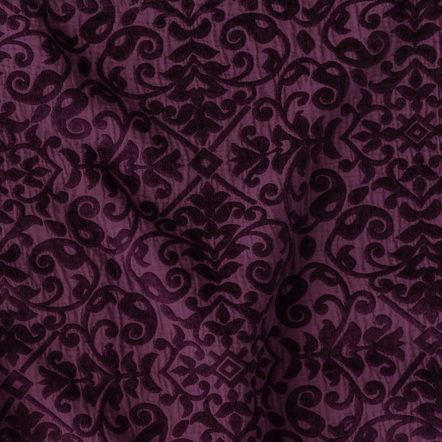 Fig: A close up of Vienna cotton chenille jacquard in fig, a richly saturated purple-garnet.