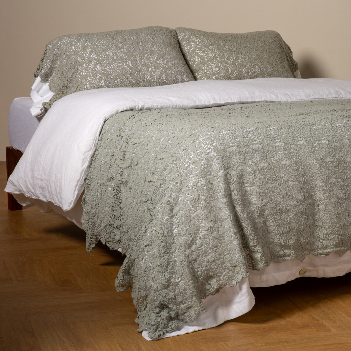 Eucalyptus: cotton lace bed scarf draped across the foot of a bed dressed in linen sheets and duvet cover in winter white -  shown with matching lace pillowcase covers over a linen liner in winter white. 