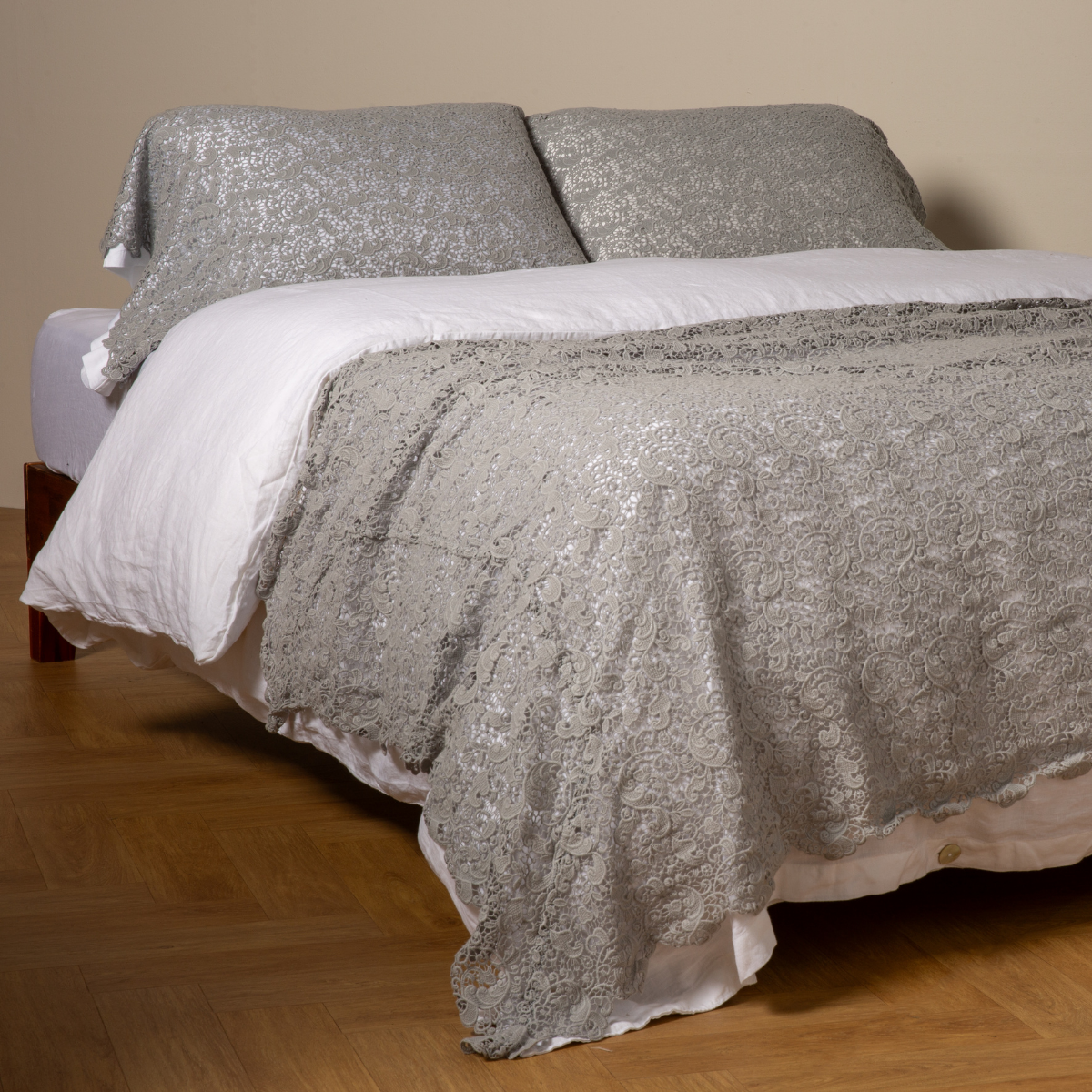 Mineral: cotton lace bed scarf draped across the foot of a bed dressed in linen sheets and duvet cover in winter white -  shown with matching lace pillowcase covers over a linen liner in winter white. 
