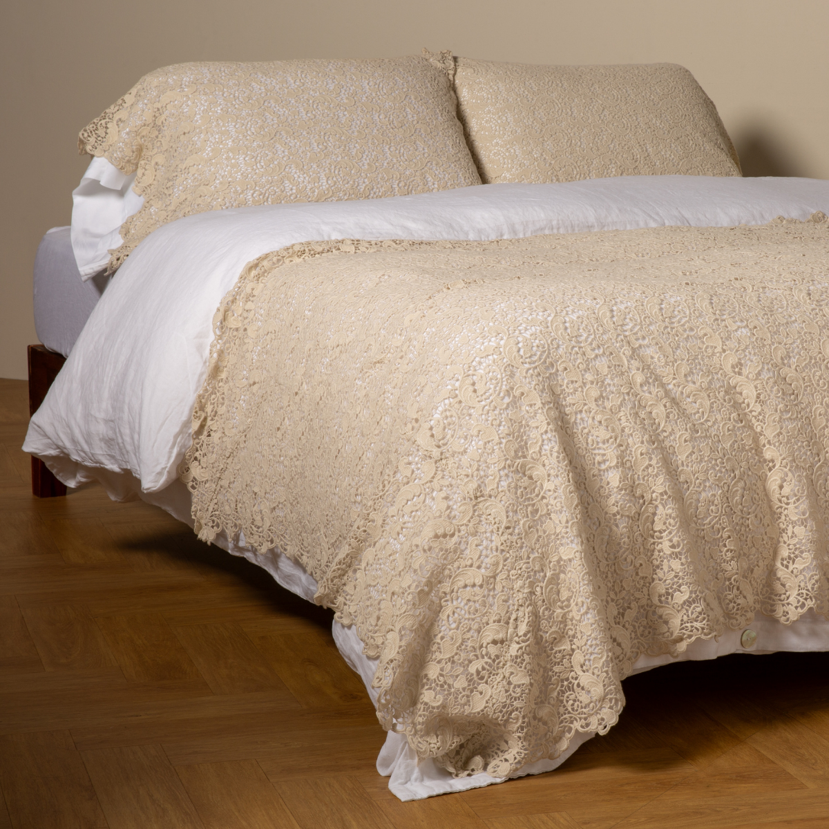 Parchment: cotton lace bed scarf draped across the foot of a bed dressed in linen sheets and duvet cover in winter white -  shown with matching lace pillowcase covers over a linen liner in winter white. 