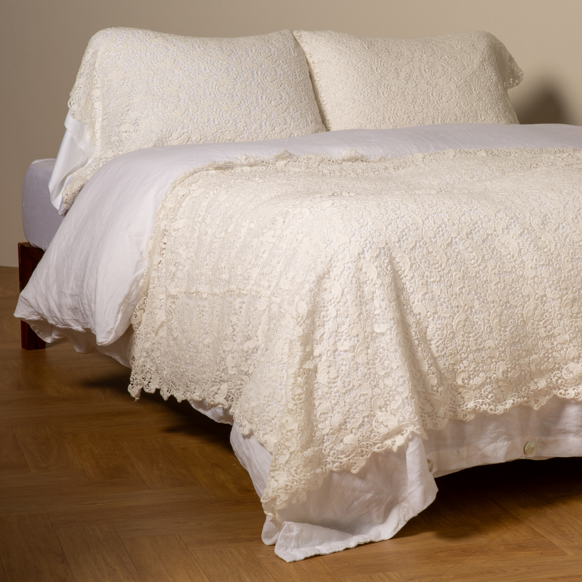 Winter White: cotton lace bed scarf draped across the foot of a bed dressed in linen sheets and duvet cover in winter white -  shown with matching lace pillowcase covers over a linen liner in winter white. 