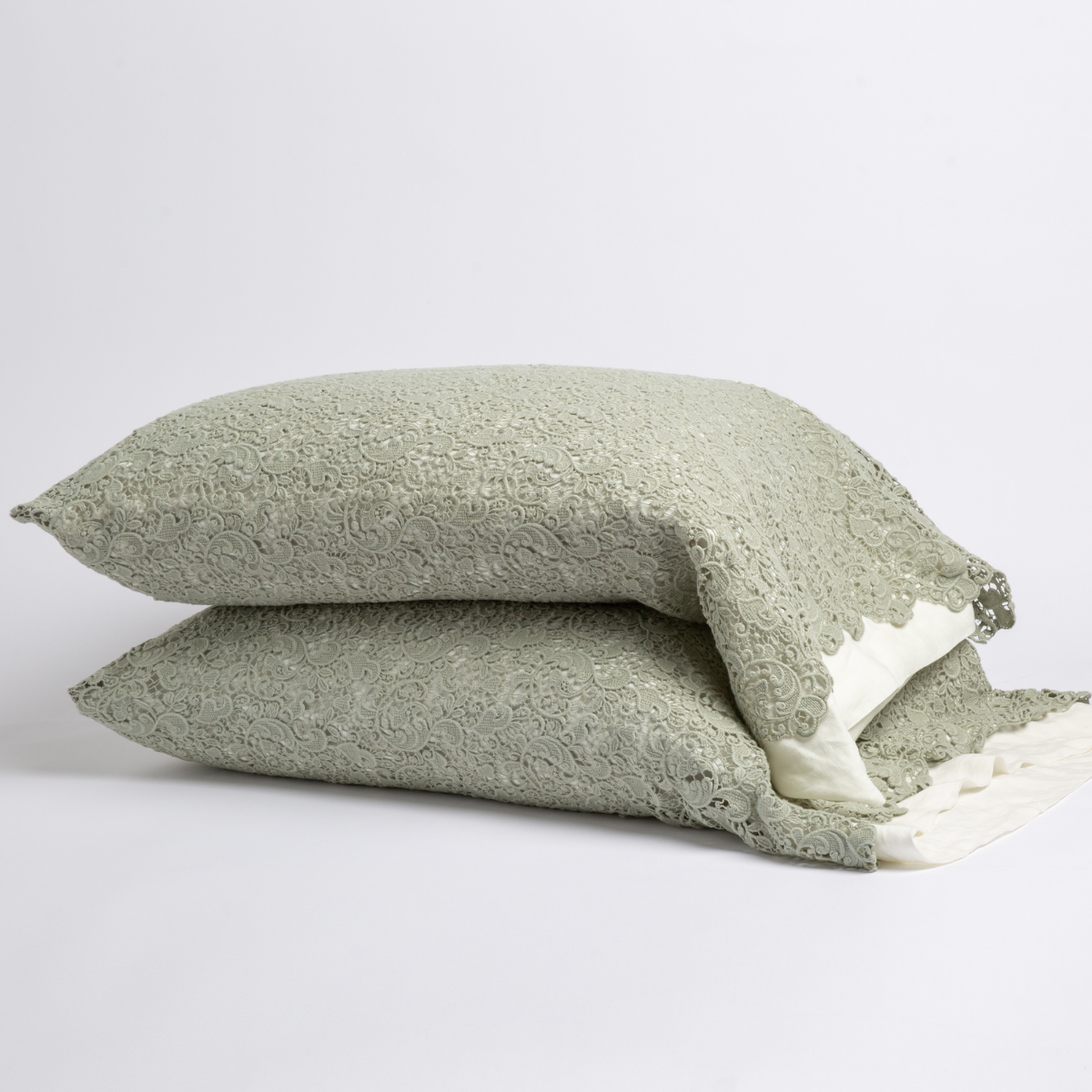 Eucalyptus: a pair of stacked cotton lace pillowcase covers on winter white liners against a white background. 