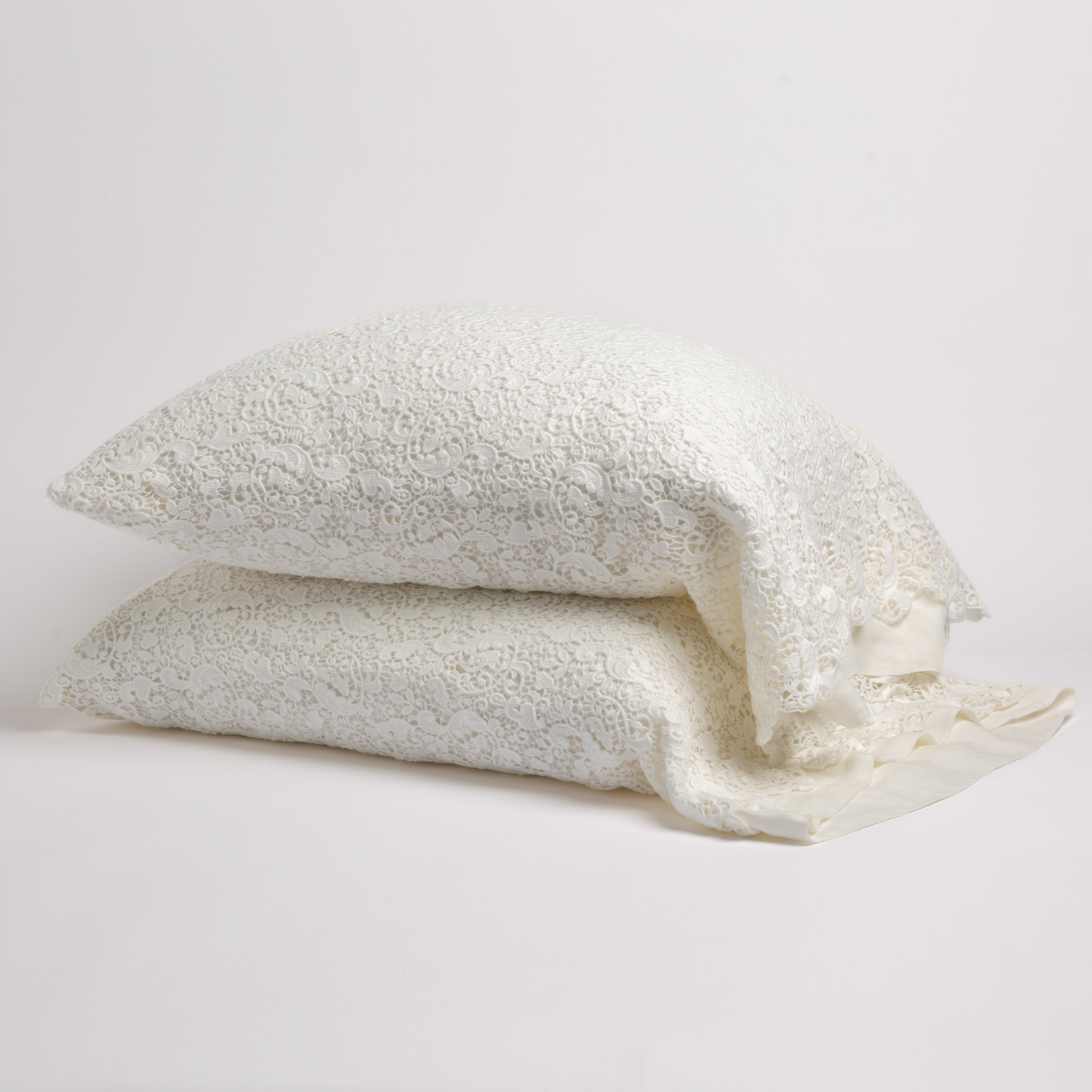 Winter White: a pair of cotton lace pillowcase covers on winter white liners against a white background. 