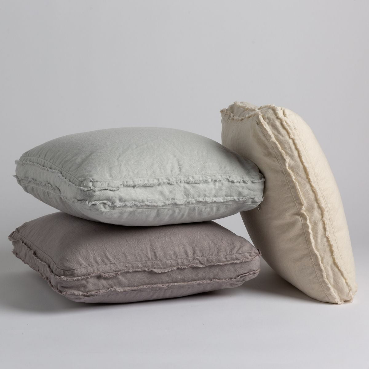 [allvariants]: Three midweight linen throw pillows on a white background. Pillows shown in Eucalyptus, Moonlight and Parchment. 