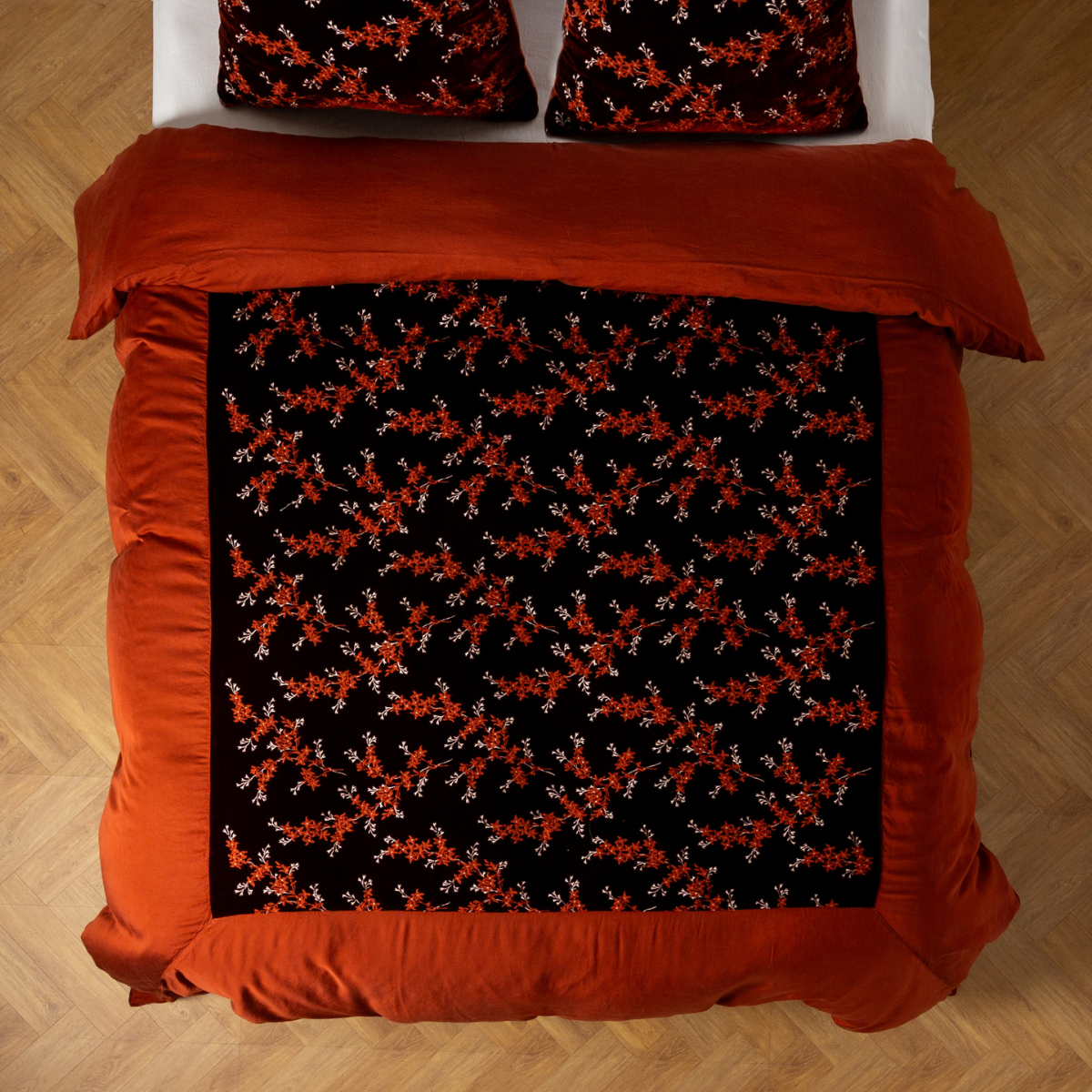 Autumn: An overhead shot of an embroidered silk velvet and tencel duvet cover and matching shams. 