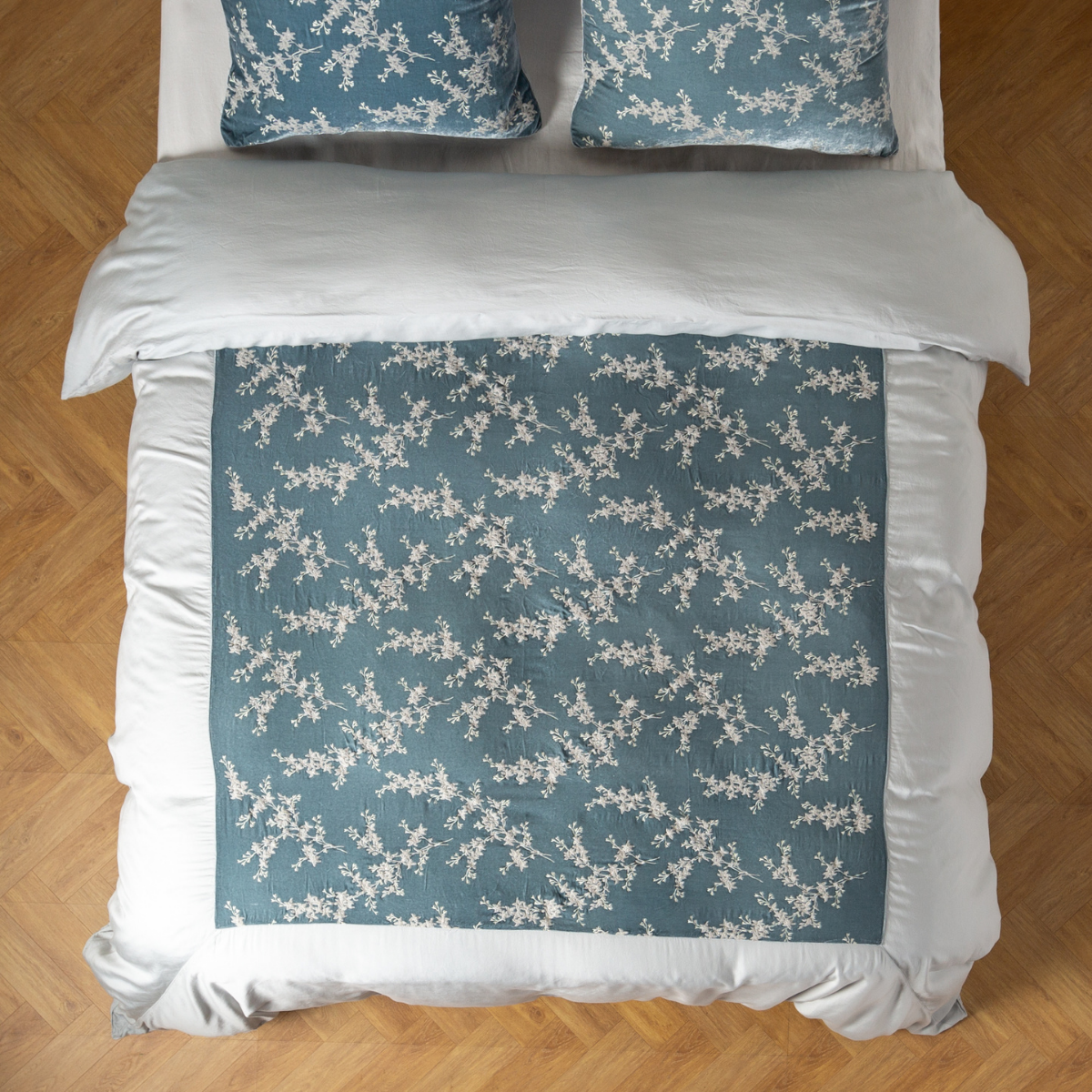 Cloud: An overhead shot of an embroidered silk velvet and tencel duvet cover and matching shams. 