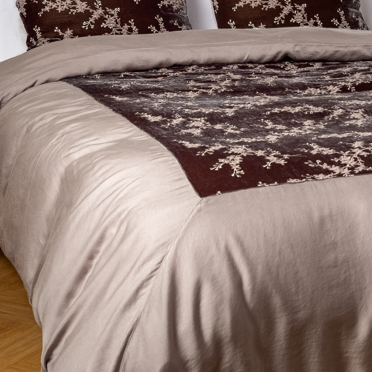 Moonlight: A close-up of the mitered corner of an embroidered silk velvet and tencel duvet cover — its matching shams barely visible in the shot. 