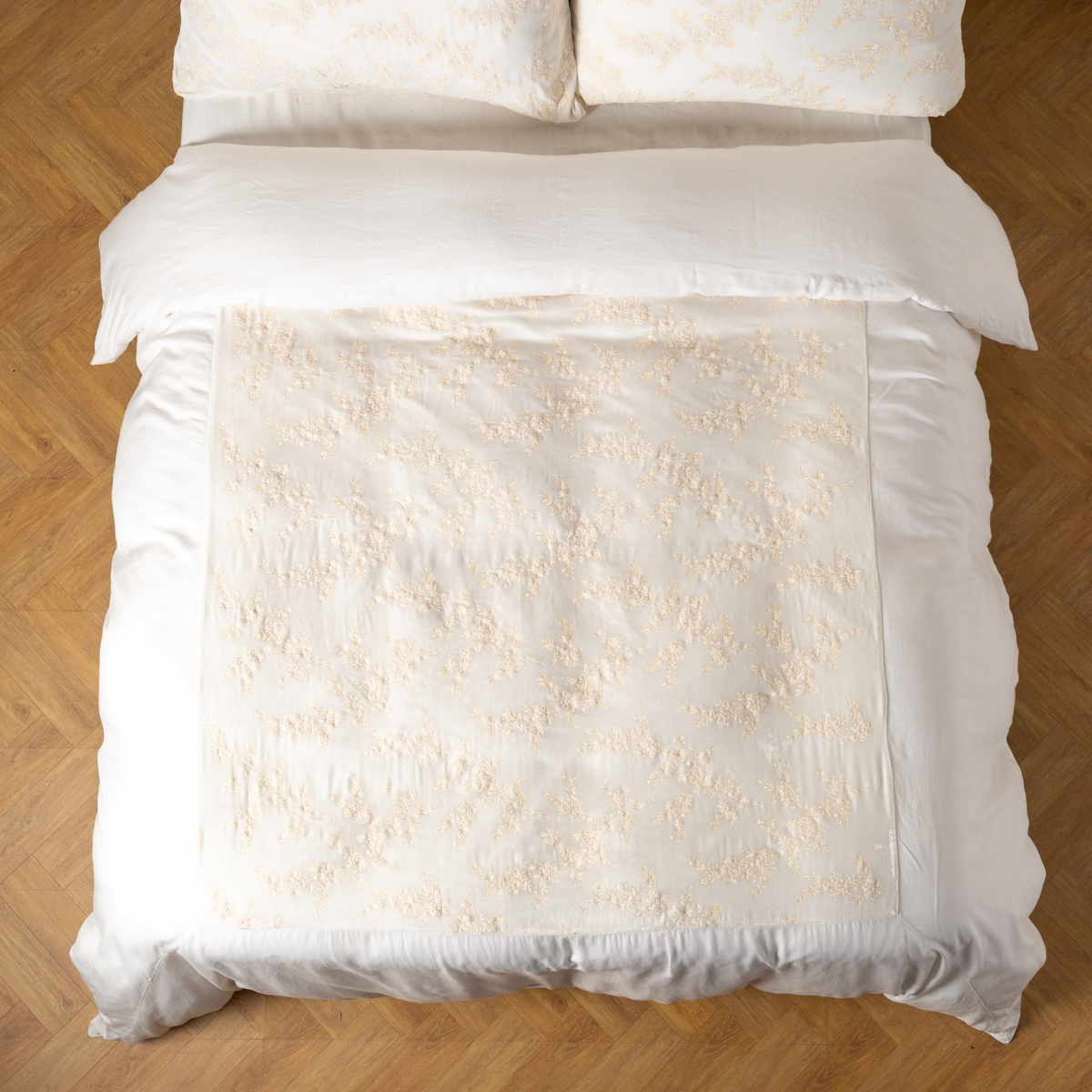 Winter White: An overhead shot of an embroidered silk velvet and tencel duvet cover and matching shams. 