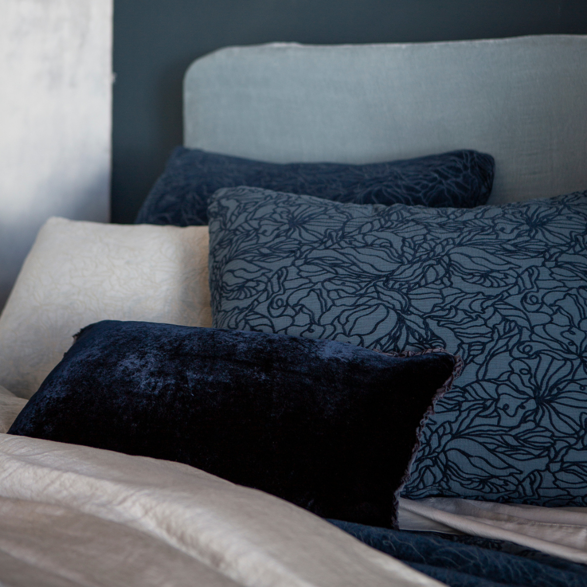[allvariants]: shams and a throw pillow shown against a light blue headboard all in blue tones. 