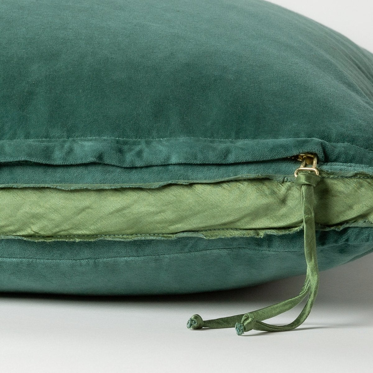 Jade: Close-up of charmeuse gusset, raw-edge trim, and brass zipper detail  on cotton velvet sham - side view.