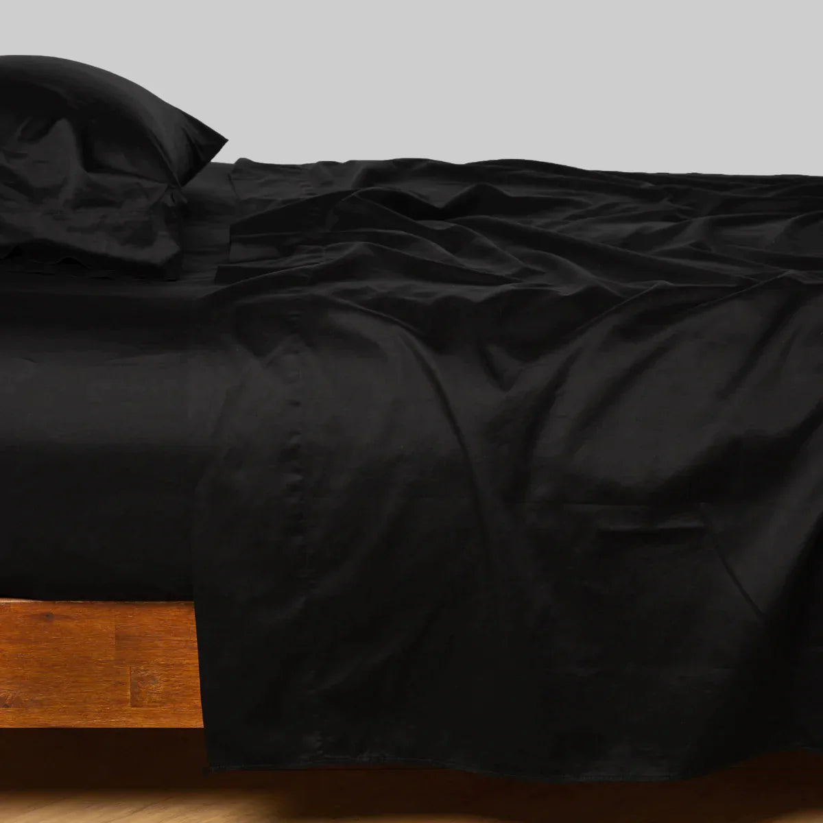 Corvino: Cotton sateen flat sheet, shown with matching fitted sheet and sleeping pillow - side view.