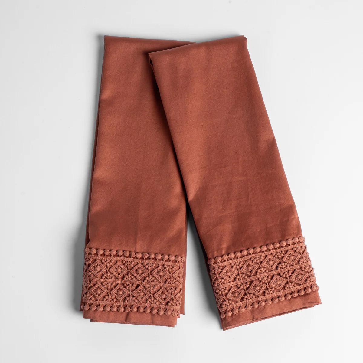 Autumn: An overhead shot of a folded pair of lace trimmed pillowcases shown side by side and slightly overlapping.