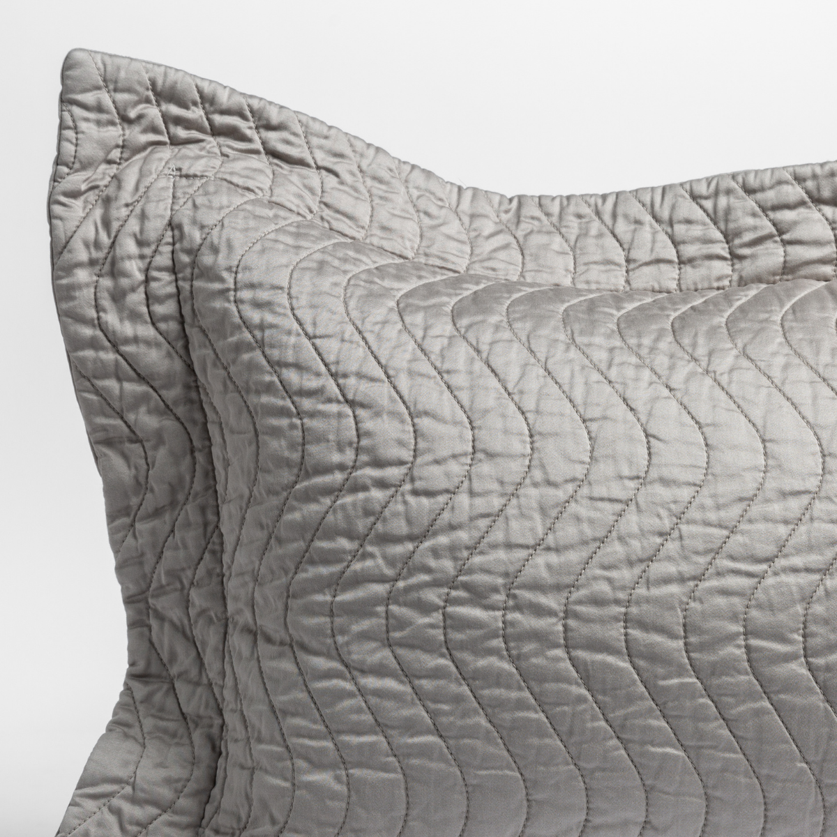 Mineral: close up of the corner of a quilted cotton sateen pillow sham - shot against a white background. 