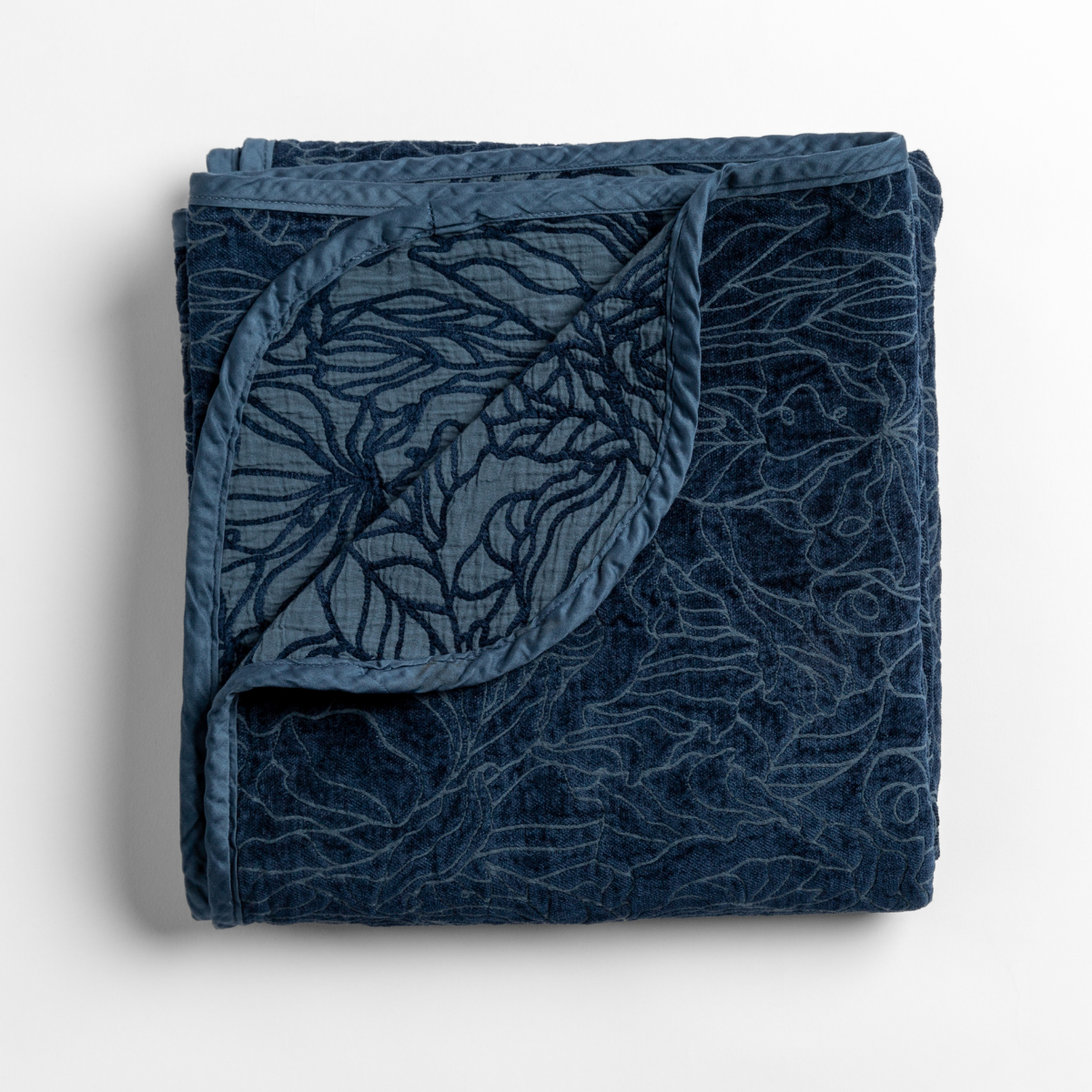 Midnight: folded blanket with its cotton jacquard side visible on the corner foldback against the chenille jacquard side. 