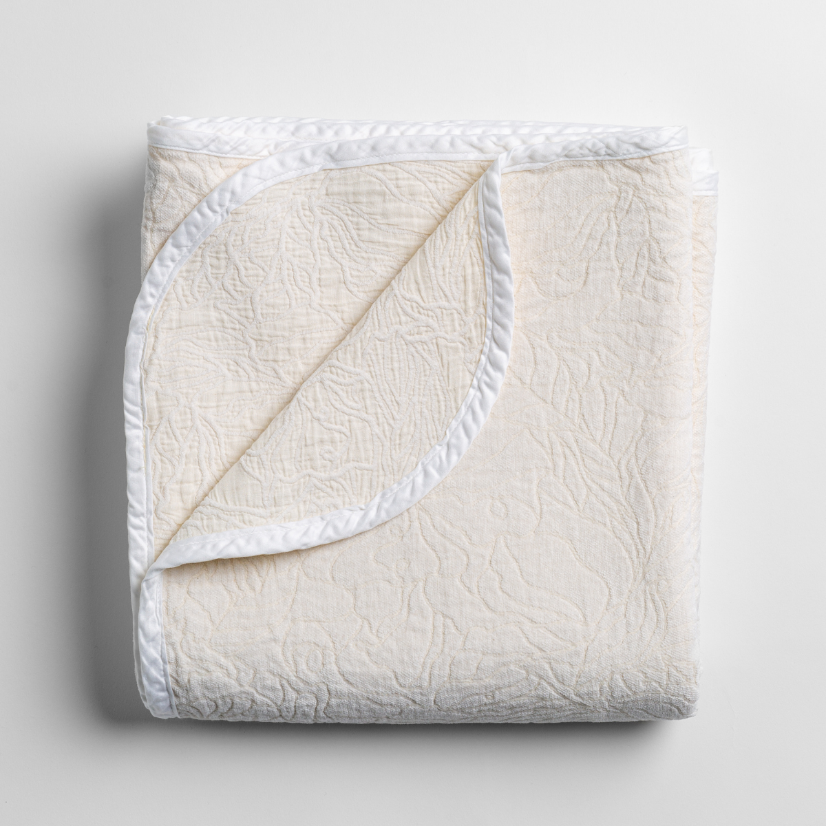 Winter White: folded blanket with its cotton jacquard side visible on the corner foldback against the chenille jacquard side. 