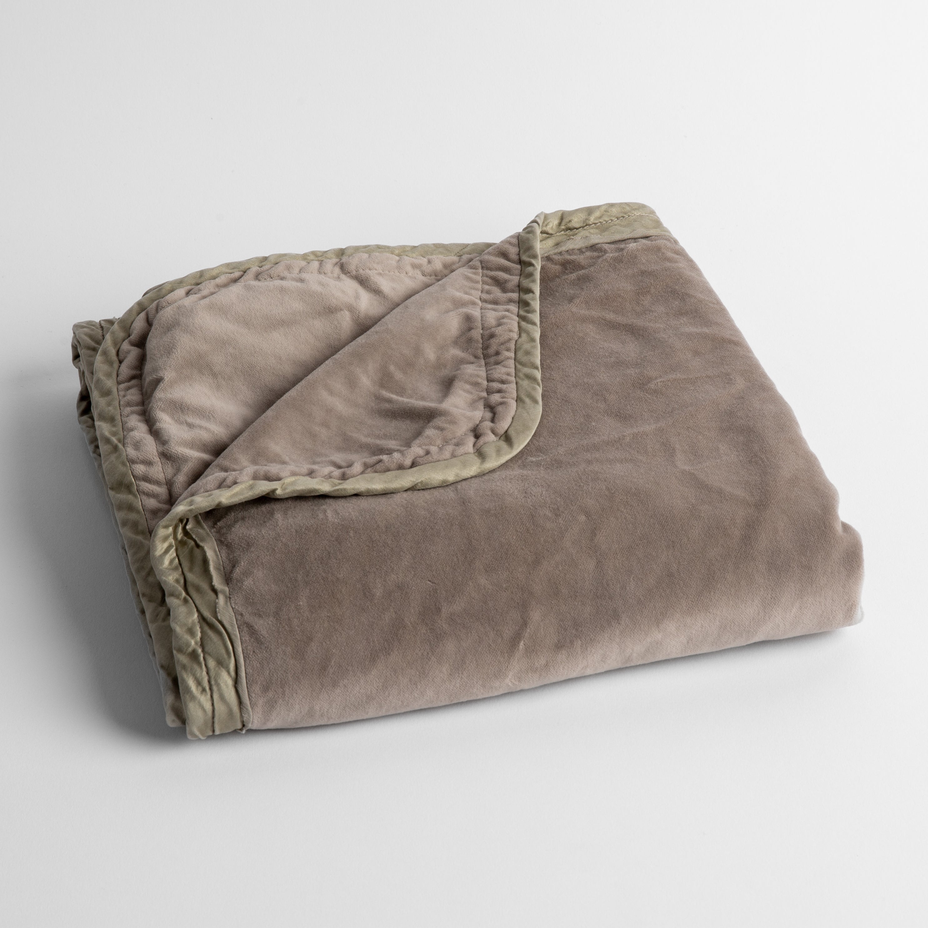 Fog: cotton velvet baby blanket trimmed with charmeuse, folded with a covern folded back to show trim contrast; shot overhead and at a slight angle against a white background. 