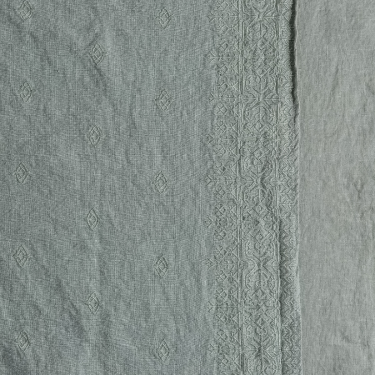 Eucalyptus: A close up of embroidered midweight linen fabric in eucalyptus, a soft light green.
