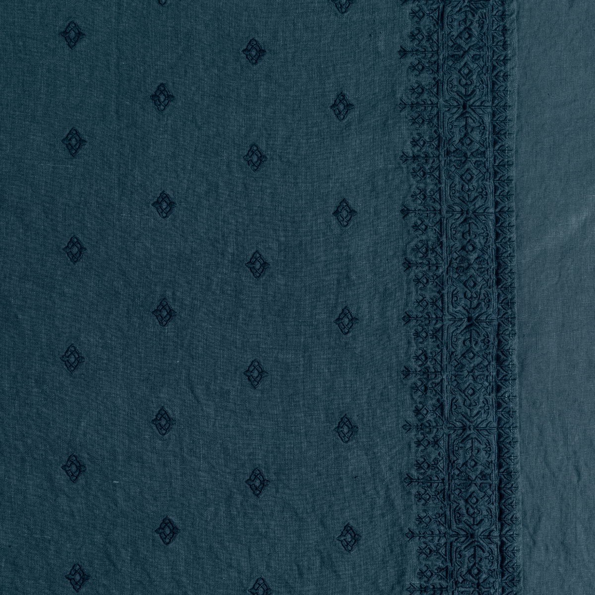 Midnight: A close up of embroidered midweight linen fabric in midnight, a rich indigo tone.