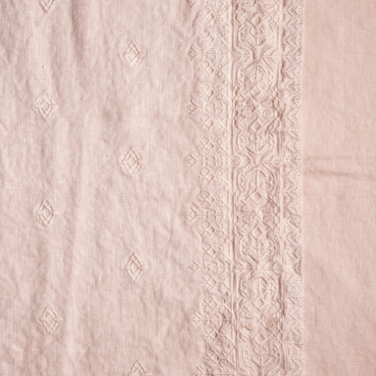 Pearl: A close up of embroidered midweight linen fabric in pearl, a nude-like, soft rose pink tone.