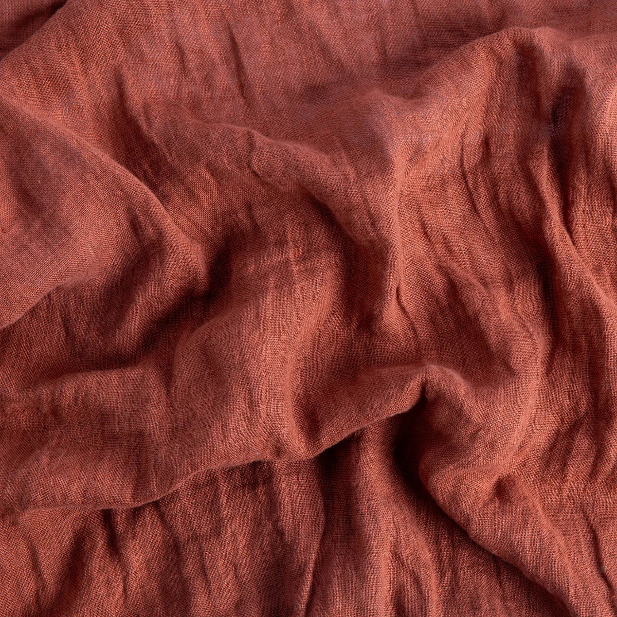 Autumn: A close up of linen whisper, our lightweight linen gauze, in autumn, a richly saturated persimmon color. 