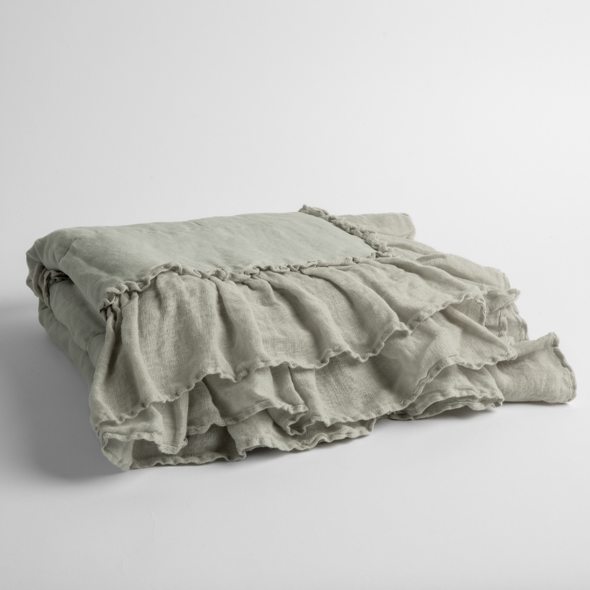 Cloud:   a folded linen with linen whisper ruffled blanket folded and positioned to show the ruffle detail against a white background and slightly overhead. 